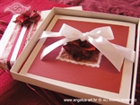 crvena pozivnica u kutiji s laticama i bijelom mašnom