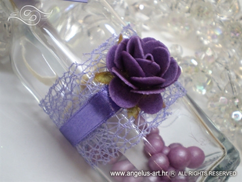 ljubičasta pozivnica u boci s ružom i mrežom