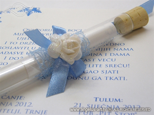 plava epruveta s pozivnicom za vjenčanje i bijelom ružom