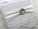 white lace wedding invitation with brooch